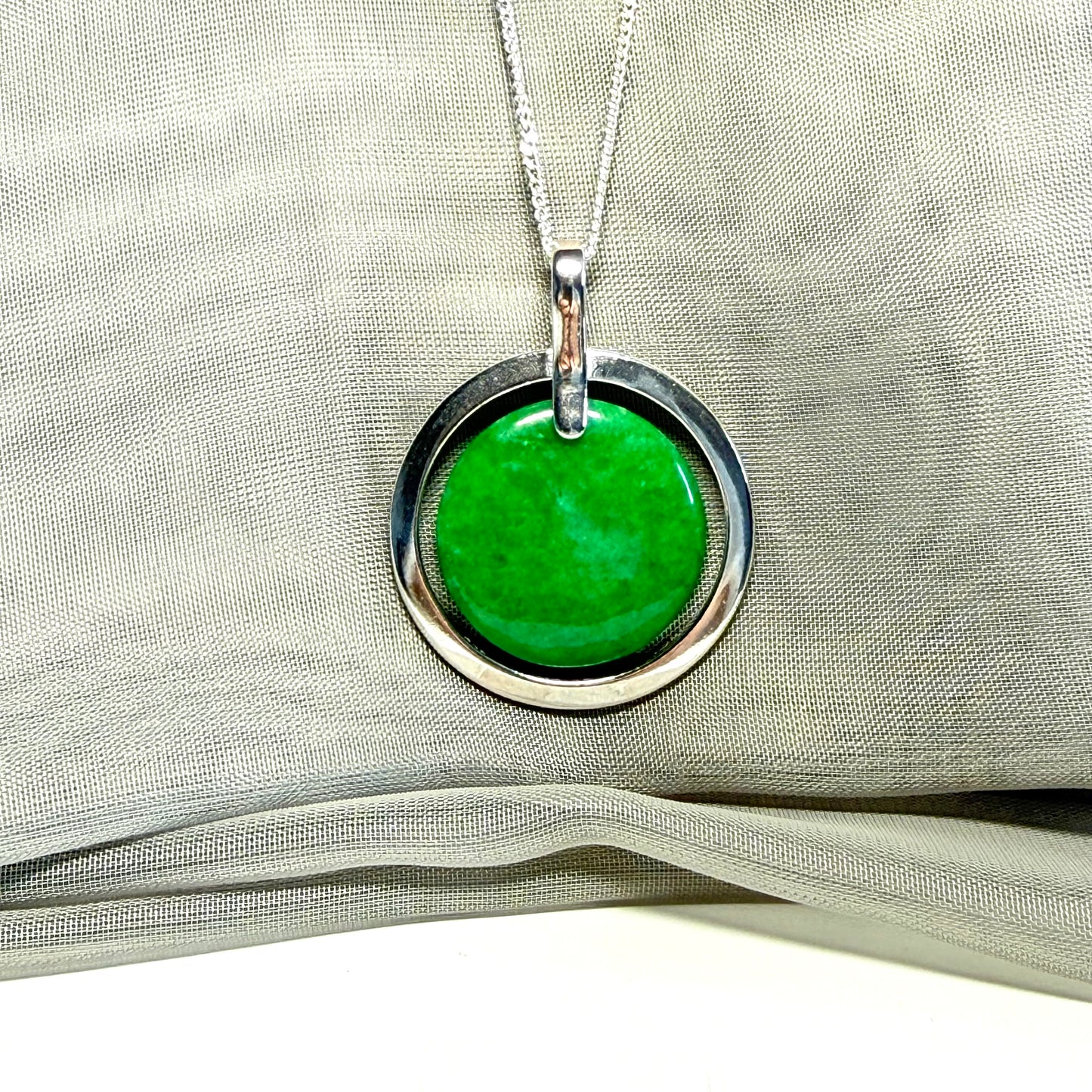 Green pendant necklace on a light fabric background