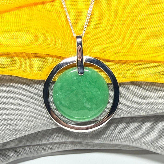 A large sterling silver green real jade necklace halo style, a traditionally designed round pendant