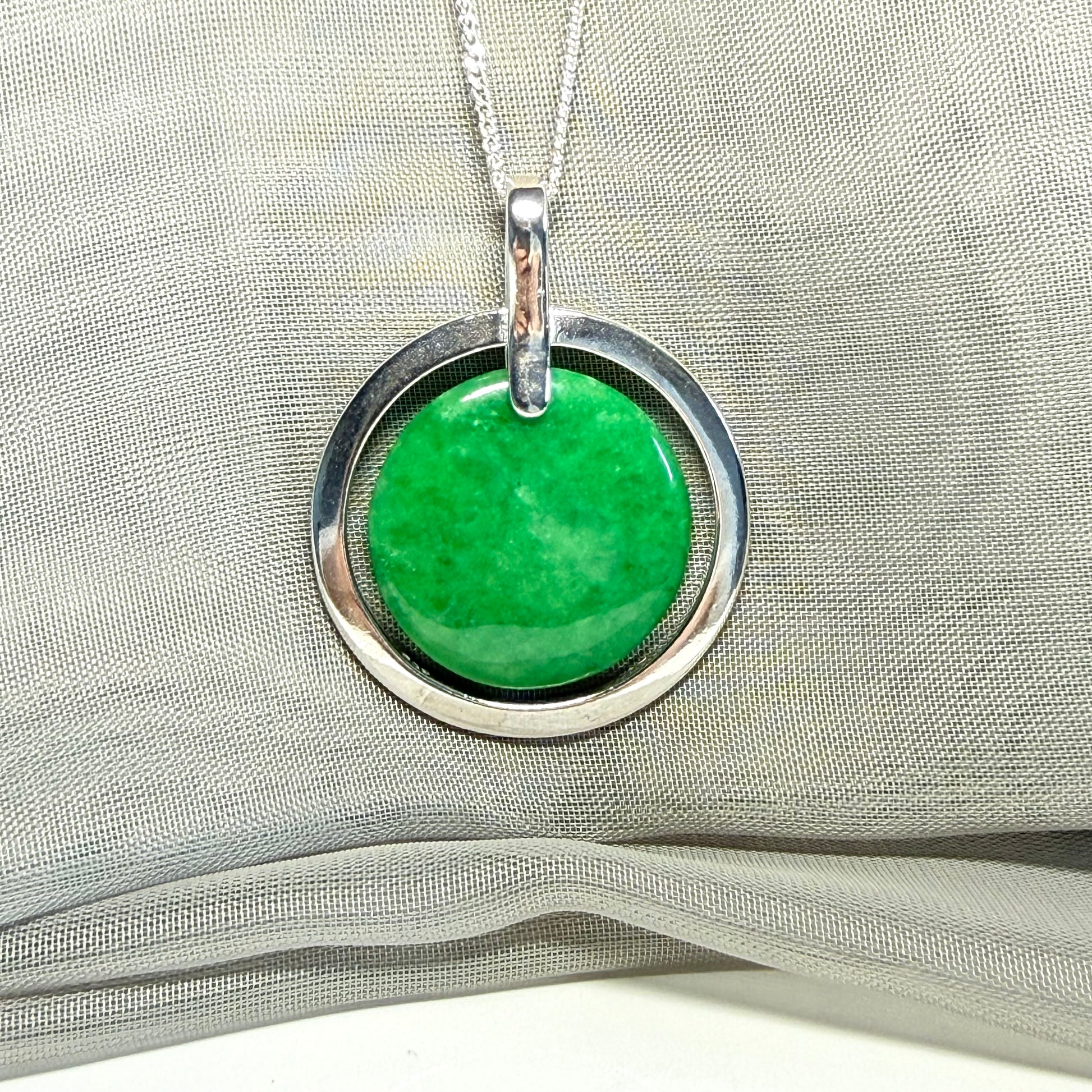 A large sterling silver round shaped green real jade necklace halo style, a stunning and timeless pendant design