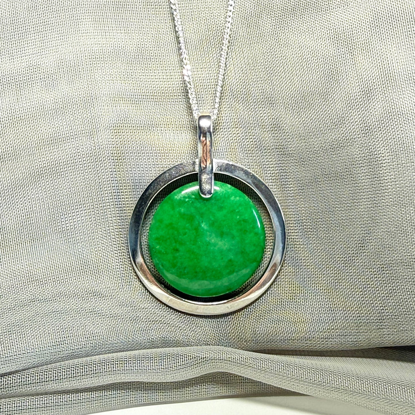 A large sterling silver round shaped green real jade necklace halo style, a stunning and timeless pendant design