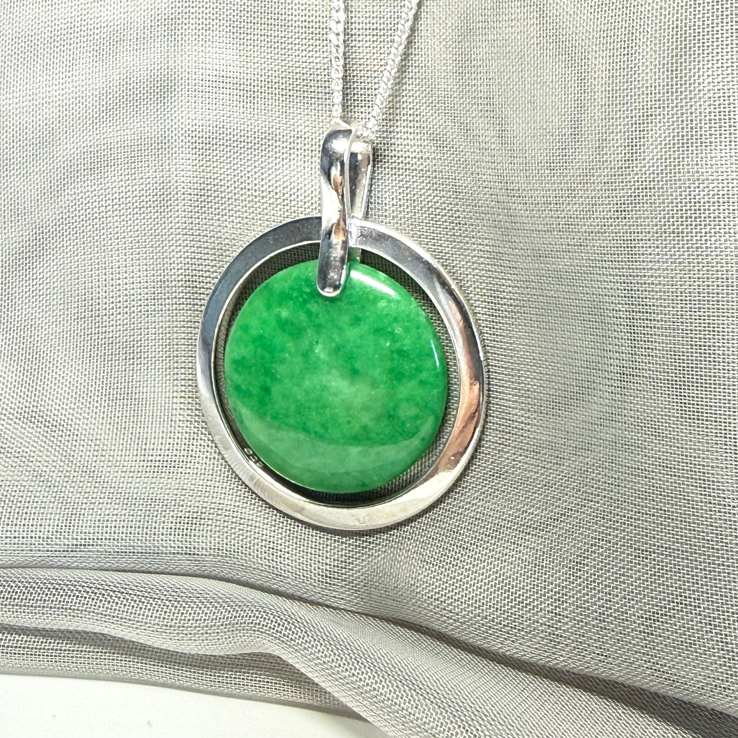A large sterling silver round shaped green real jade necklace halo style, a stunning and timeless pendant design