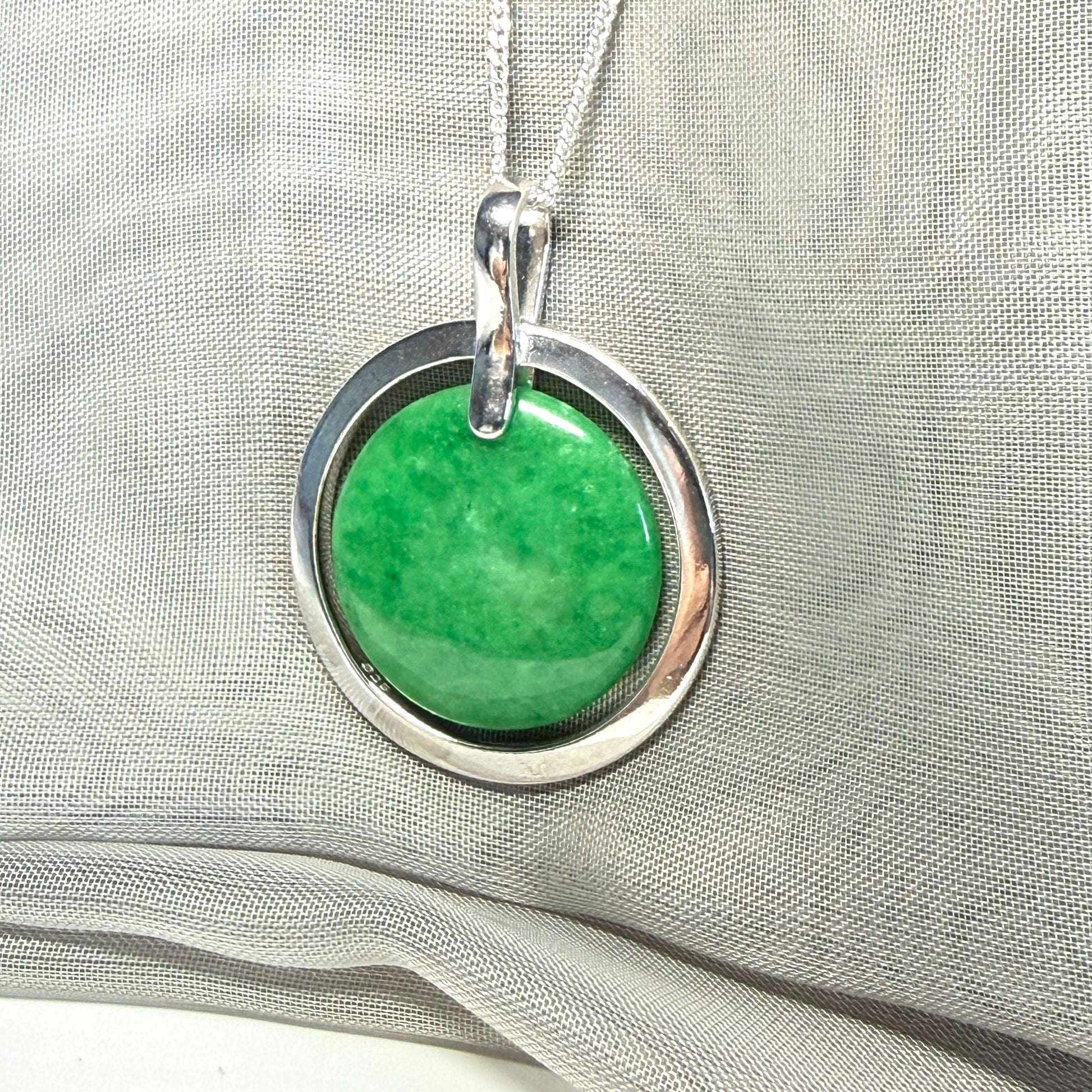 A large sterling silver round shaped green real jade necklace halo style, a stunning and timeless pendant design