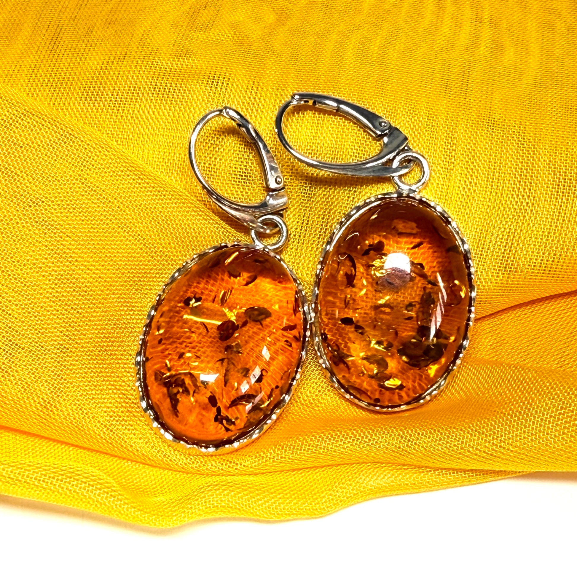 A pair of real amber drop earrings oval shaped sterling silver continental wire fittings