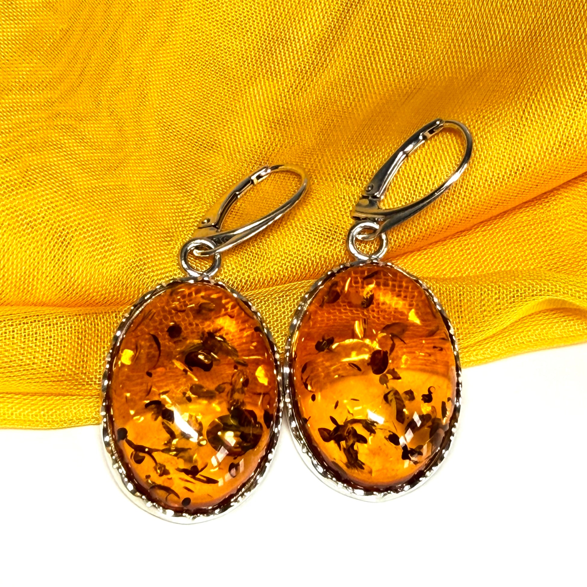 A pair of real amber drop earrings oval shaped sterling silver continental wire fittings