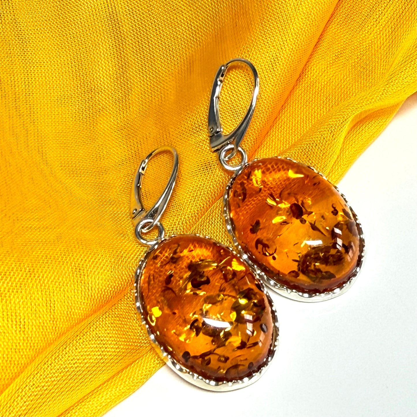 A pair of real amber drop earrings oval shaped sterling silver continental wire fittings