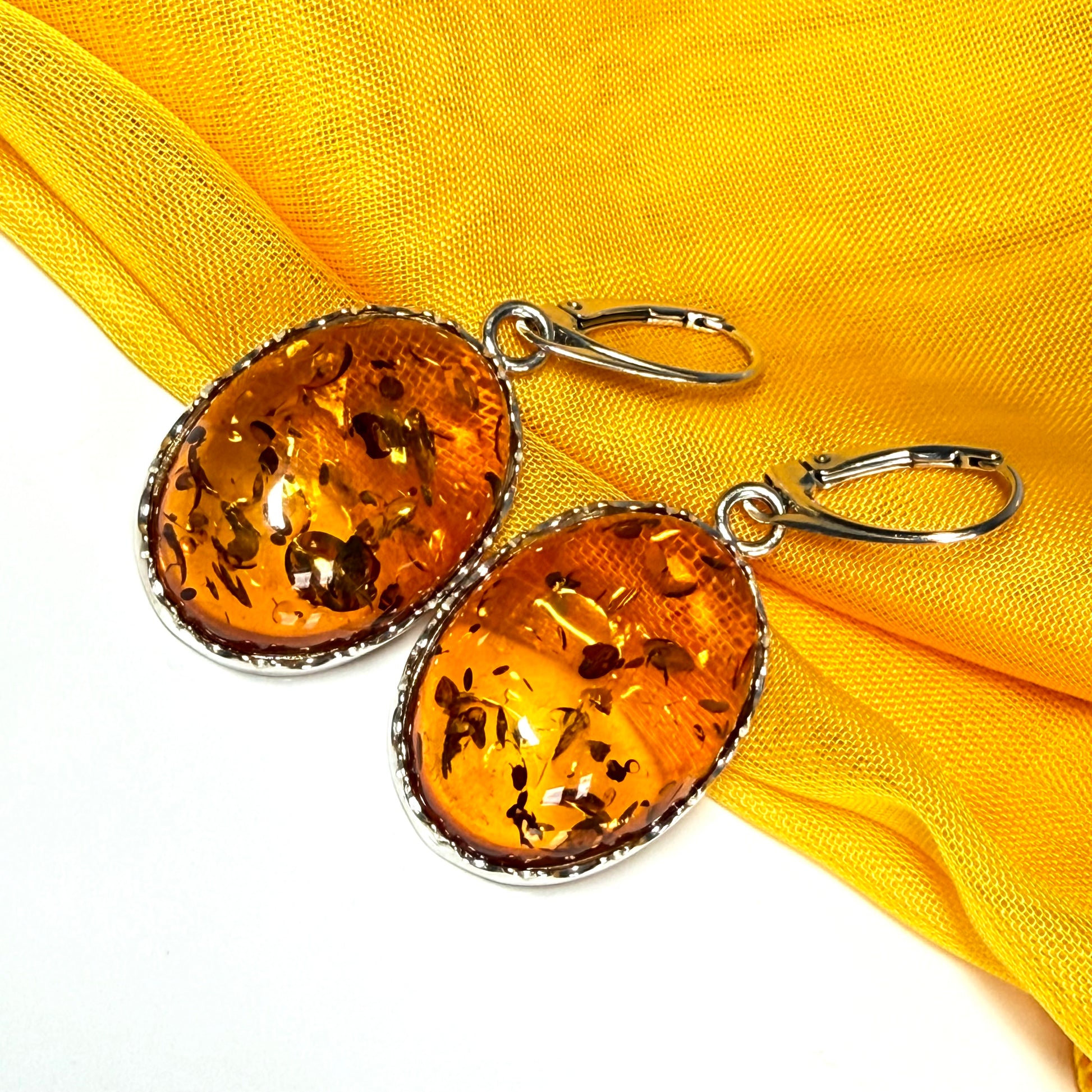 A pair of real amber drop earrings oval shaped sterling silver continental wire fittings
