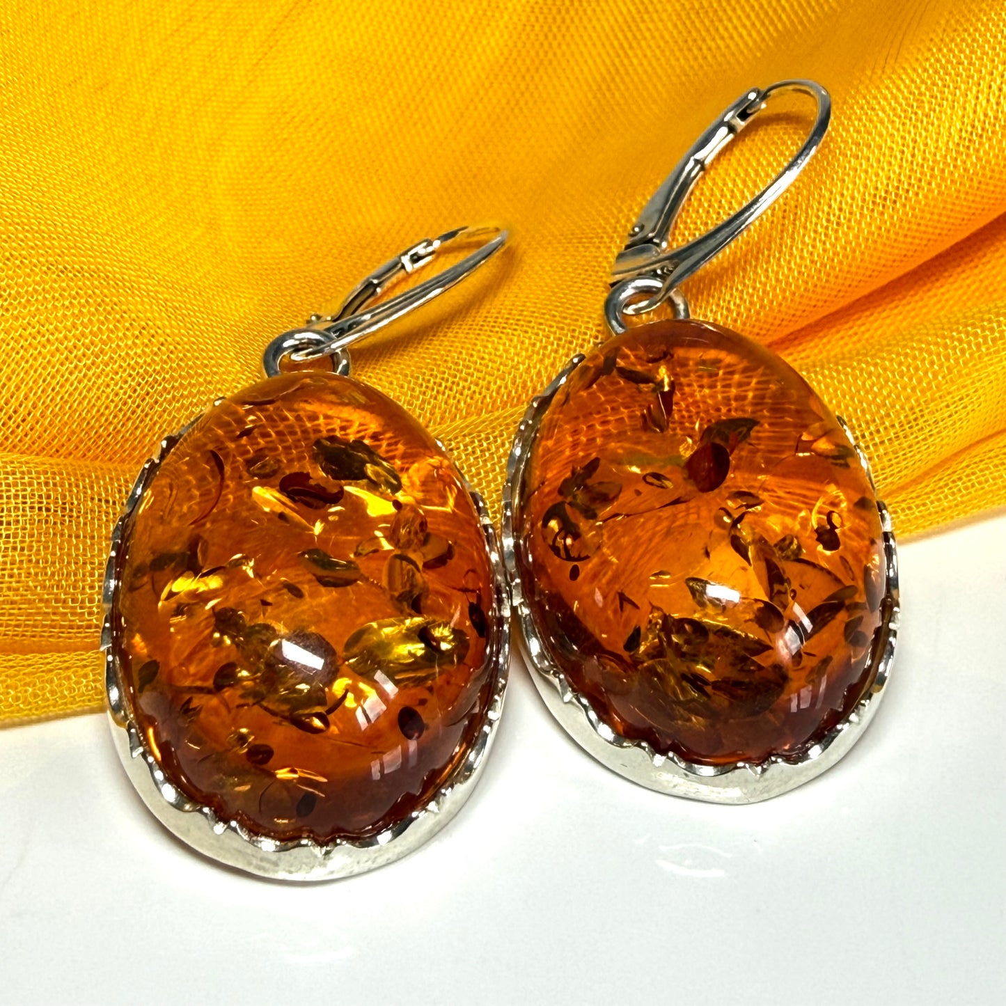 A pair of real amber drop earrings oval shaped sterling silver continental wire fittings