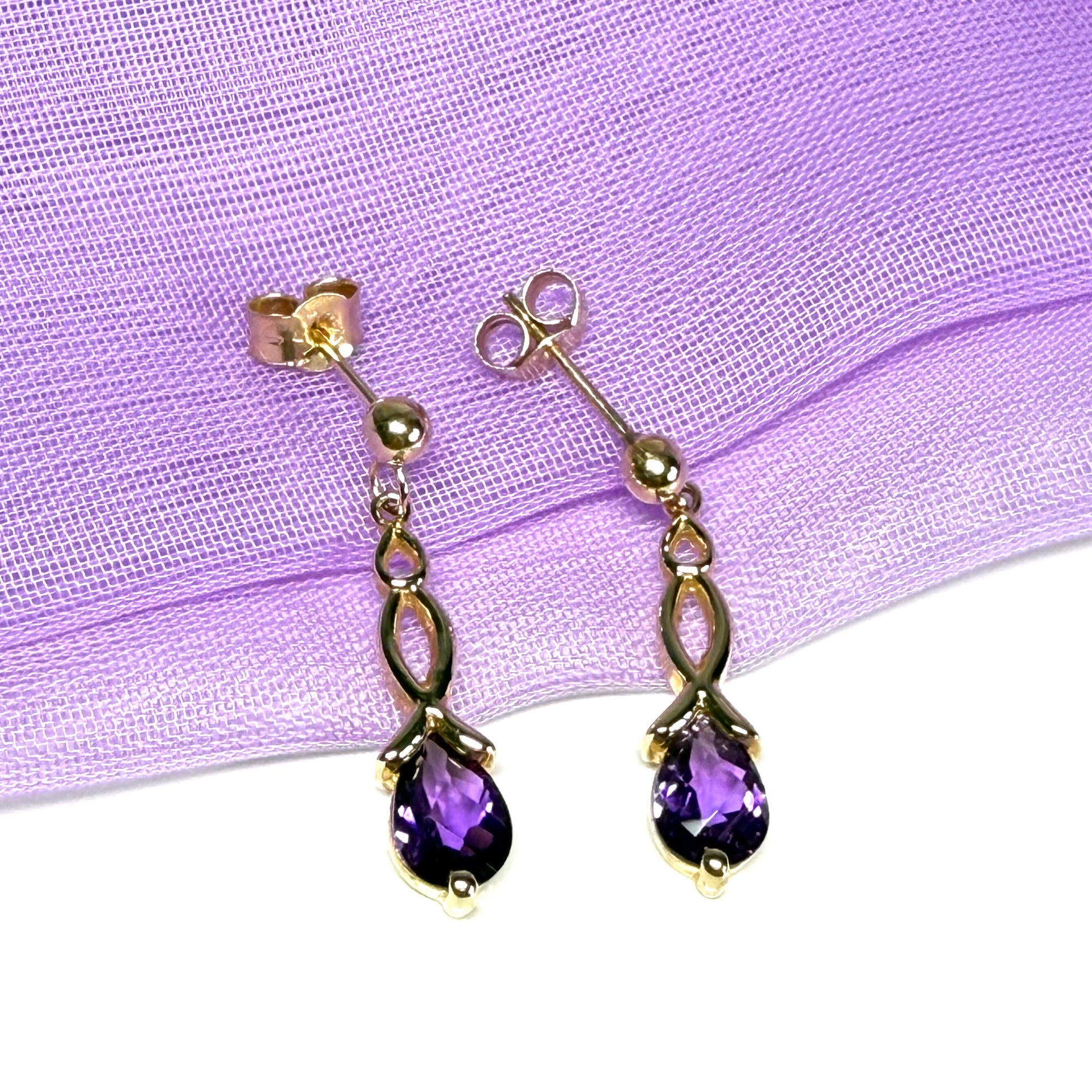 A pair of real amethyst drop earrings pear shaped yellow gold