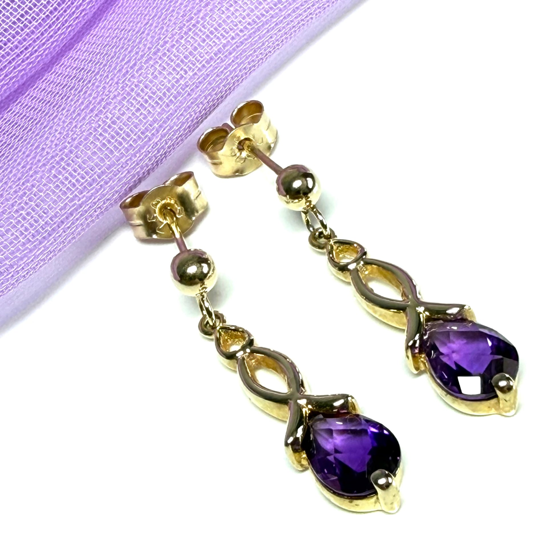 A pair of real amethyst drop earrings pear shaped yellow gold