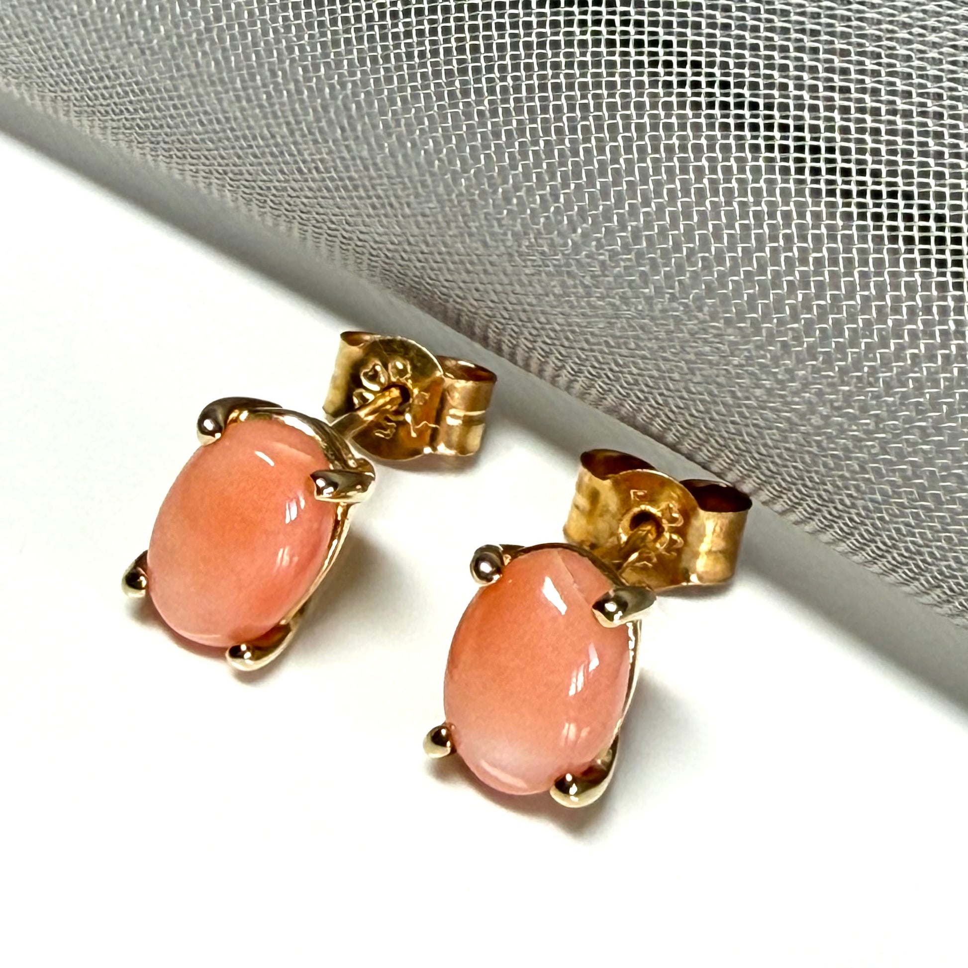 A pair of real coral oval shaped stud earrings yellow gold
