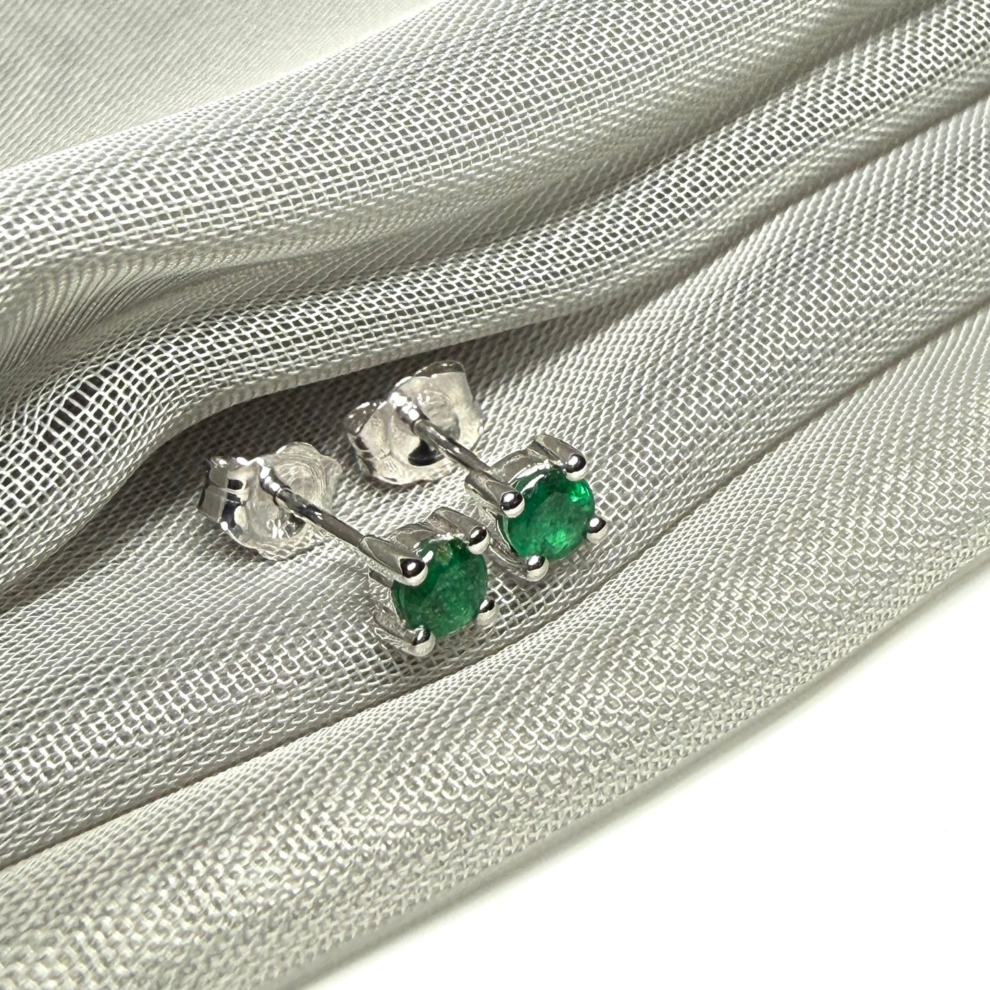 A pair of real green emerald earrings round white gold claw set studs