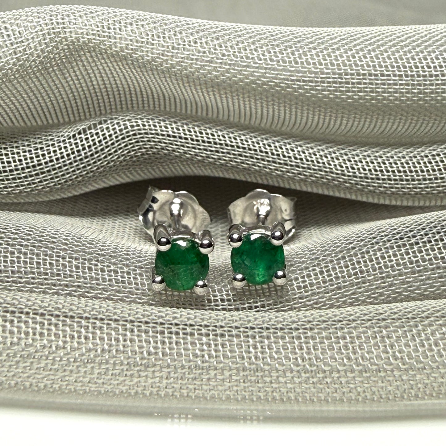 A pair of real green emerald earrings round white gold claw set studs