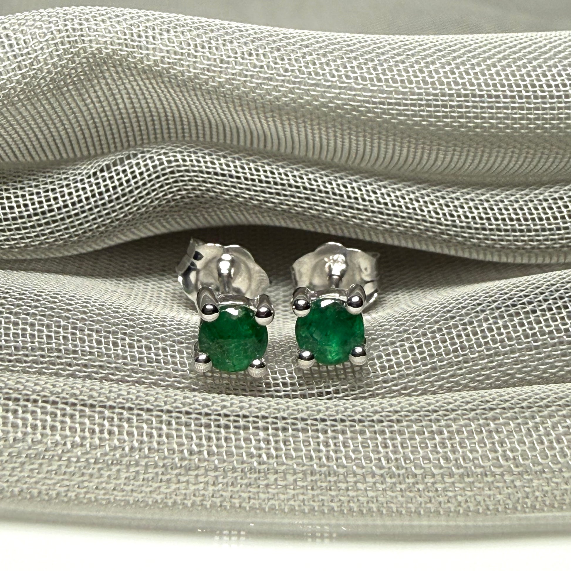A pair of real green emerald earrings round white gold claw set studs