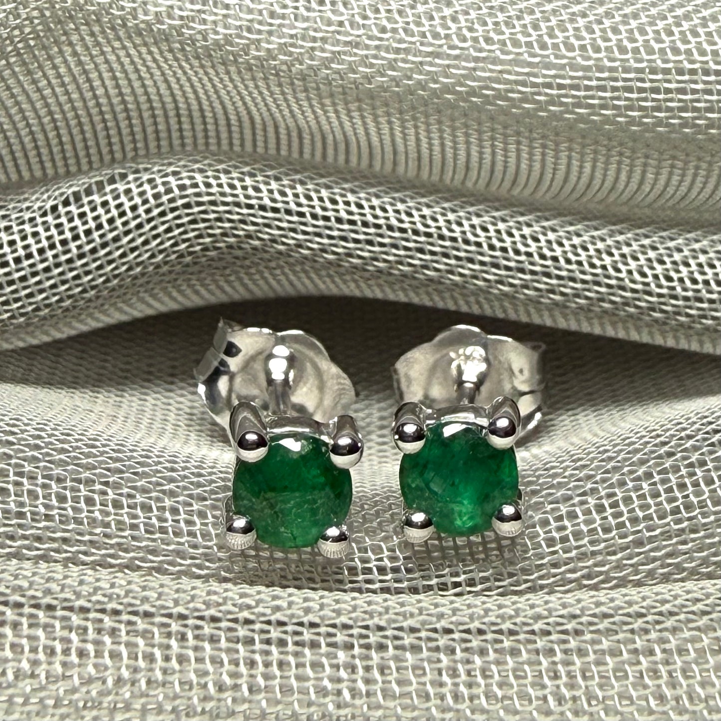 A pair of real green emerald earrings round white gold claw set studs
