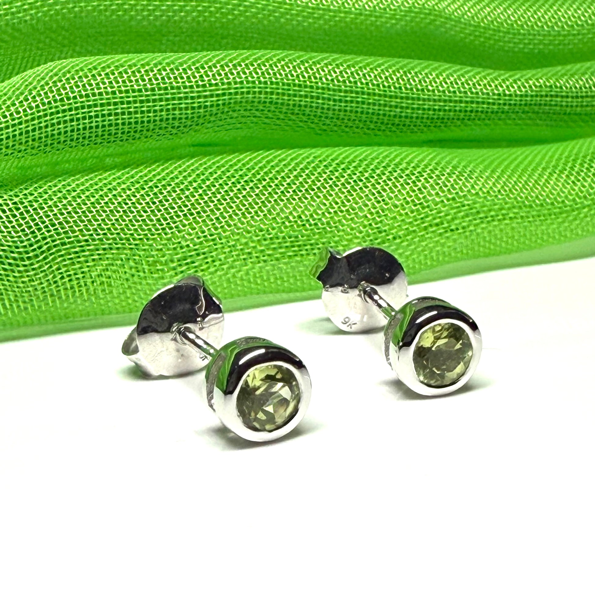 Pair of real green peridot earrings round white gold stud smooth rubbed over setting