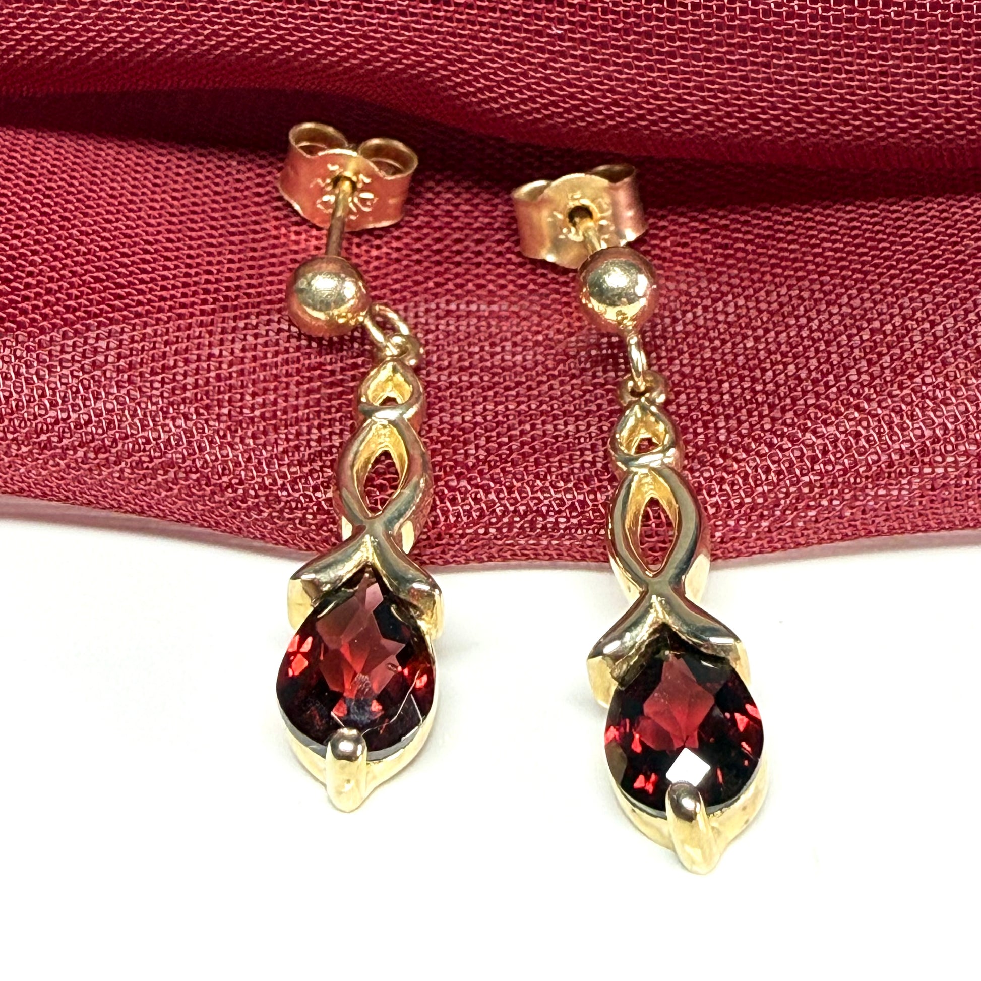 A pair of real red garnet drop earrings pear shaped yellow gold
