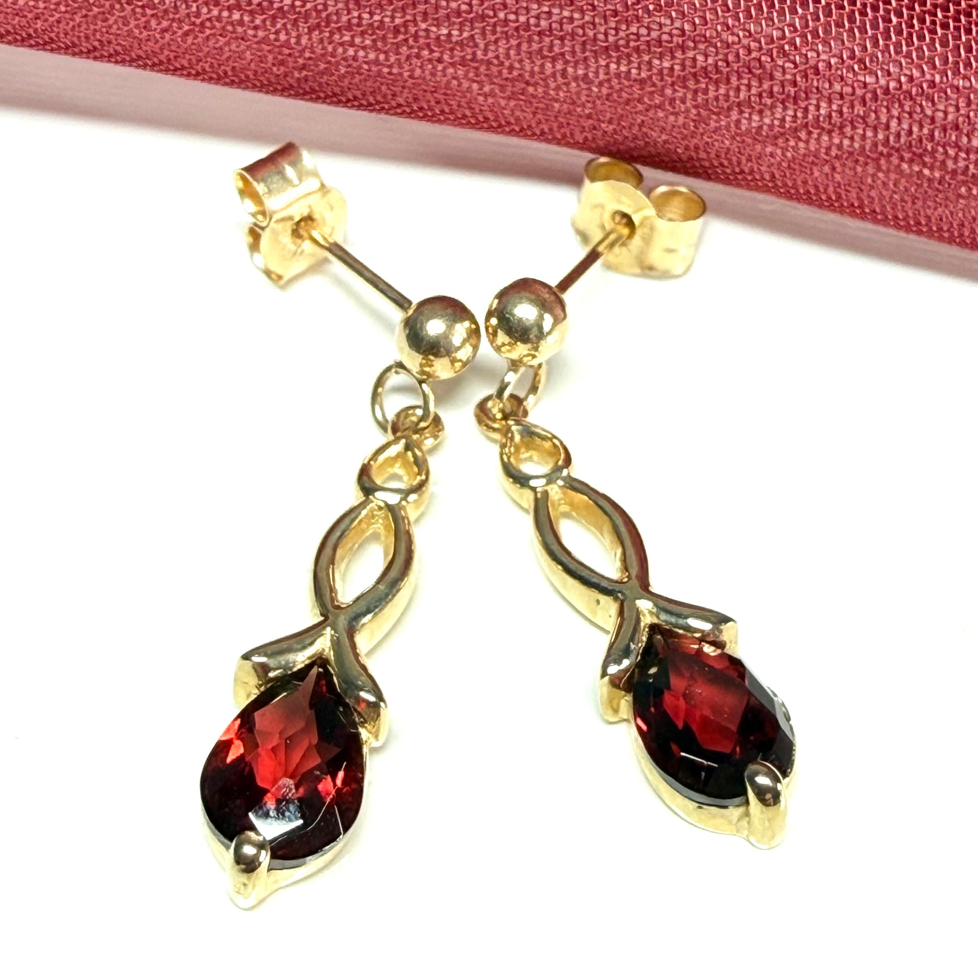 A pair of real red garnet drop earrings pear shaped yellow gold