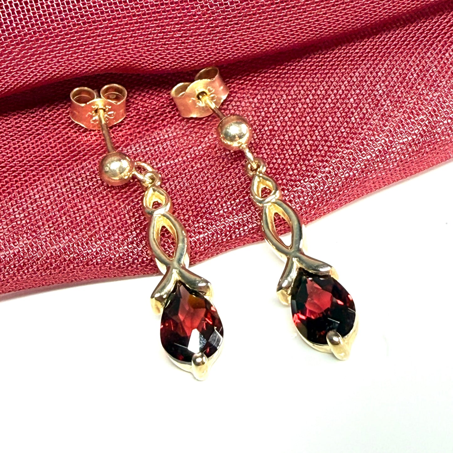 A pair of real red garnet drop earrings pear shaped yellow gold