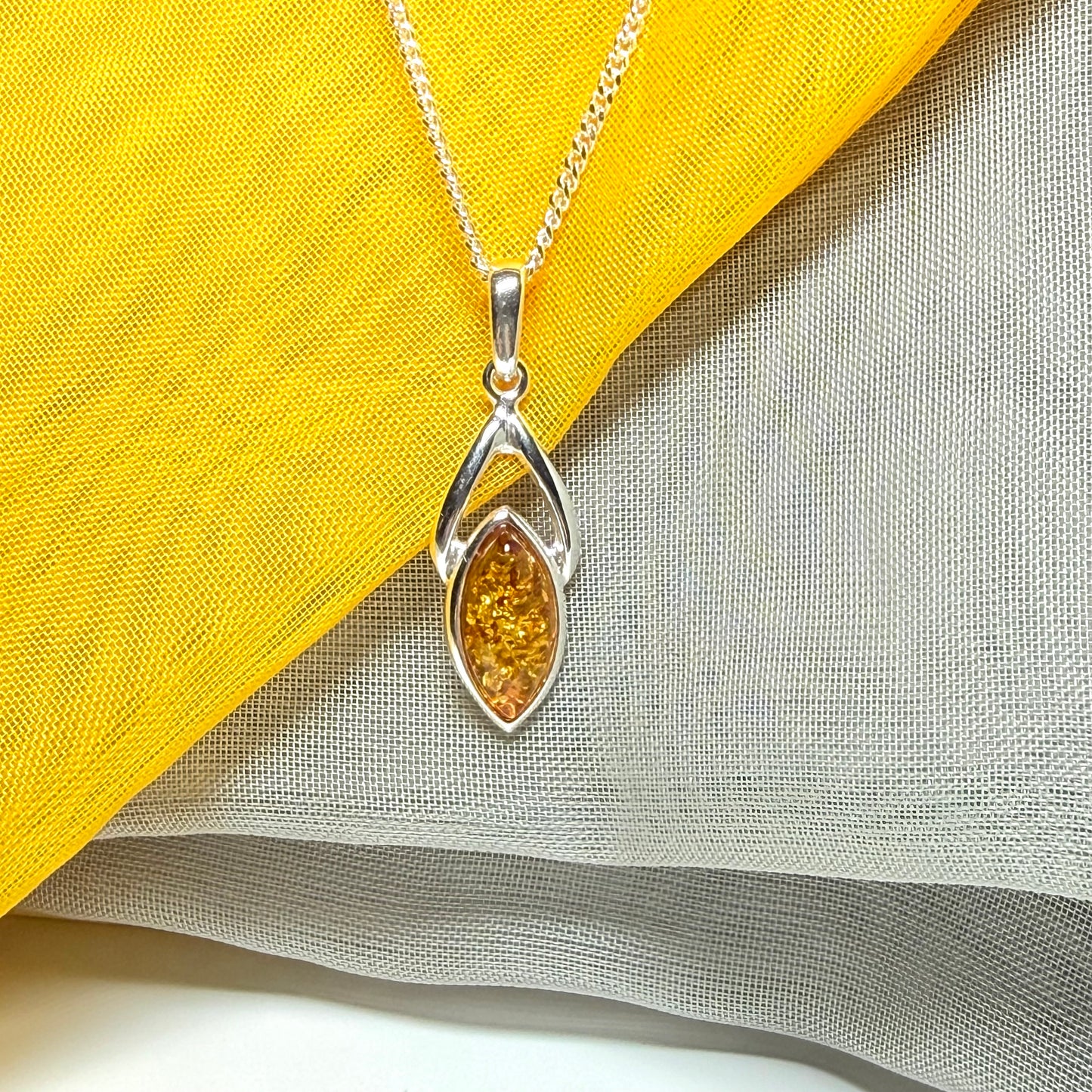 A real amber necklace sterling silver marquise shaped open pendant with chain