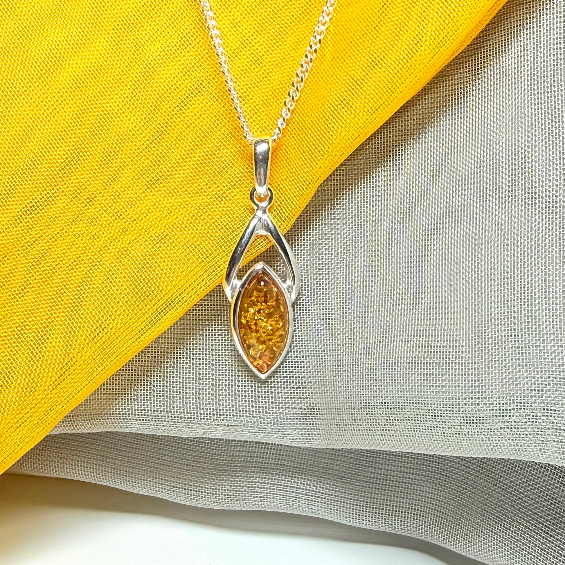 A real amber necklace sterling silver marquise shaped open pendant with chain