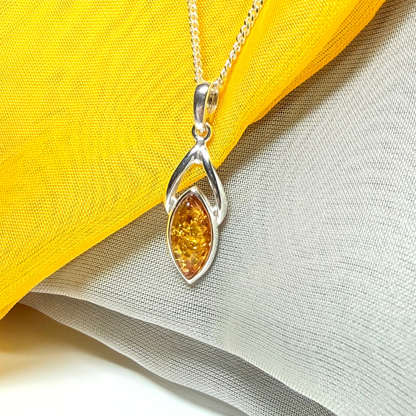 A real amber necklace sterling silver marquise shaped open pendant with chain