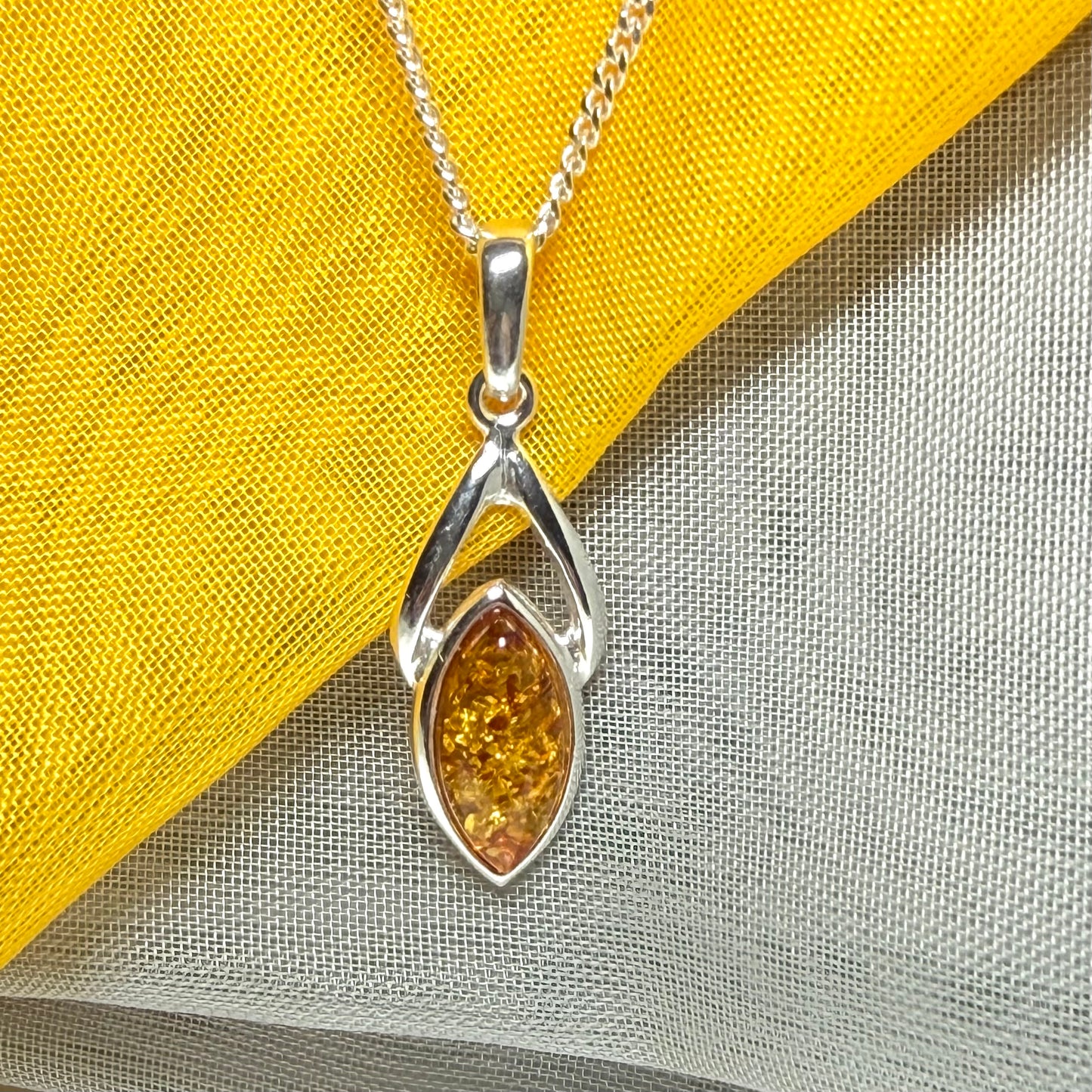 A real amber necklace sterling silver marquise shaped open pendant with chain