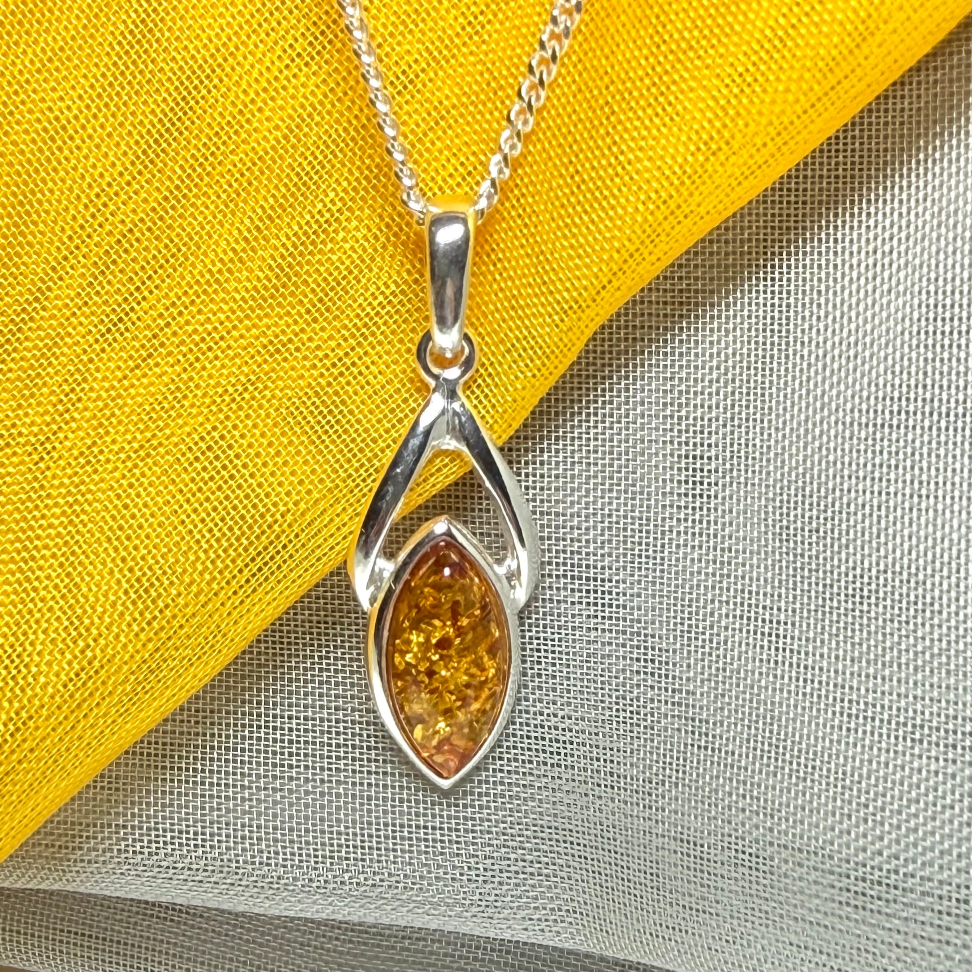 A real amber necklace sterling silver marquise shaped open pendant with chain