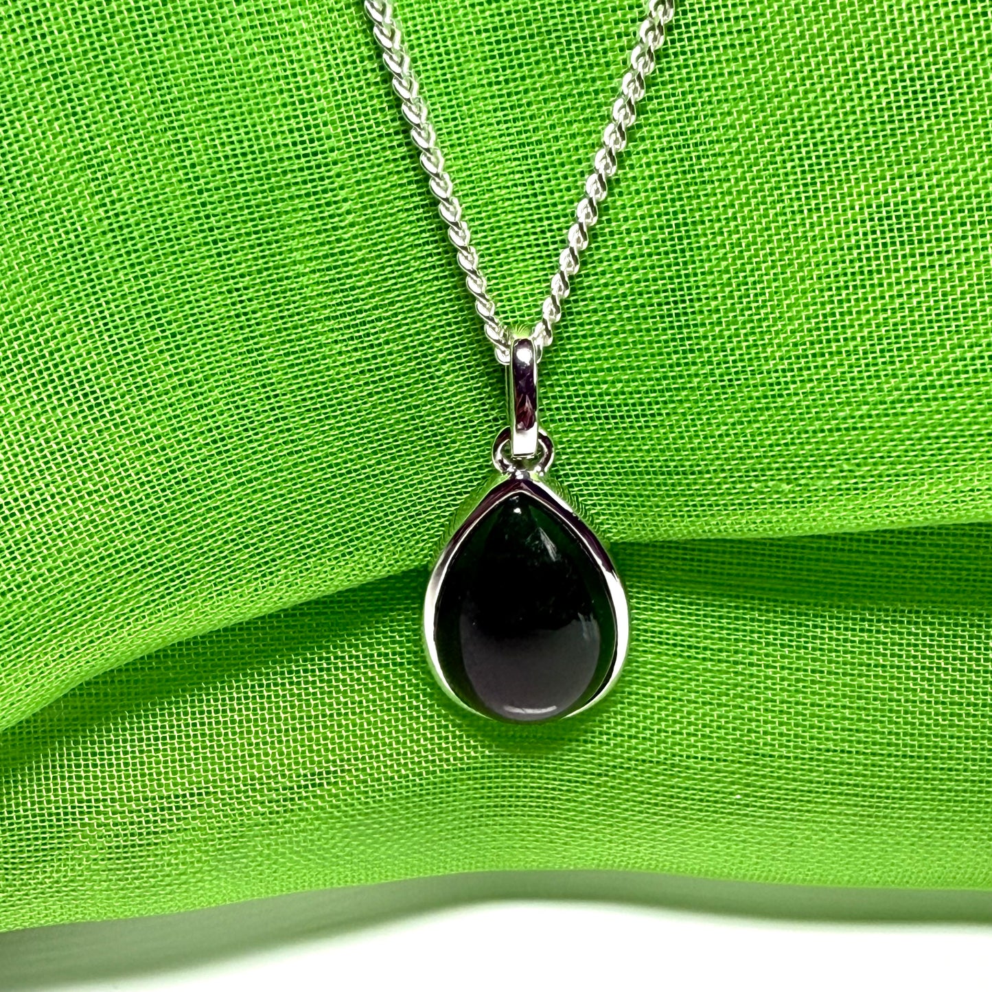 A real dark green jade necklace in a tear drop or pear shape smooth rub over setting