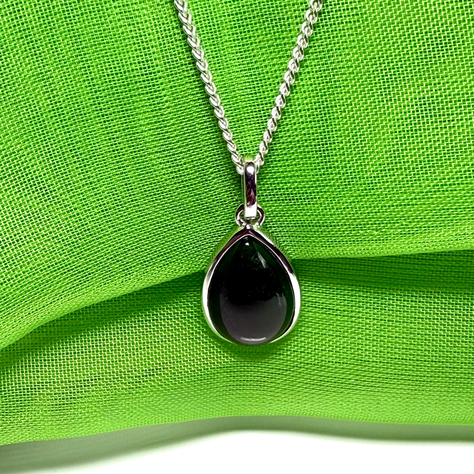 A real dark green jade necklace in a tear drop or pear shape smooth rub over setting