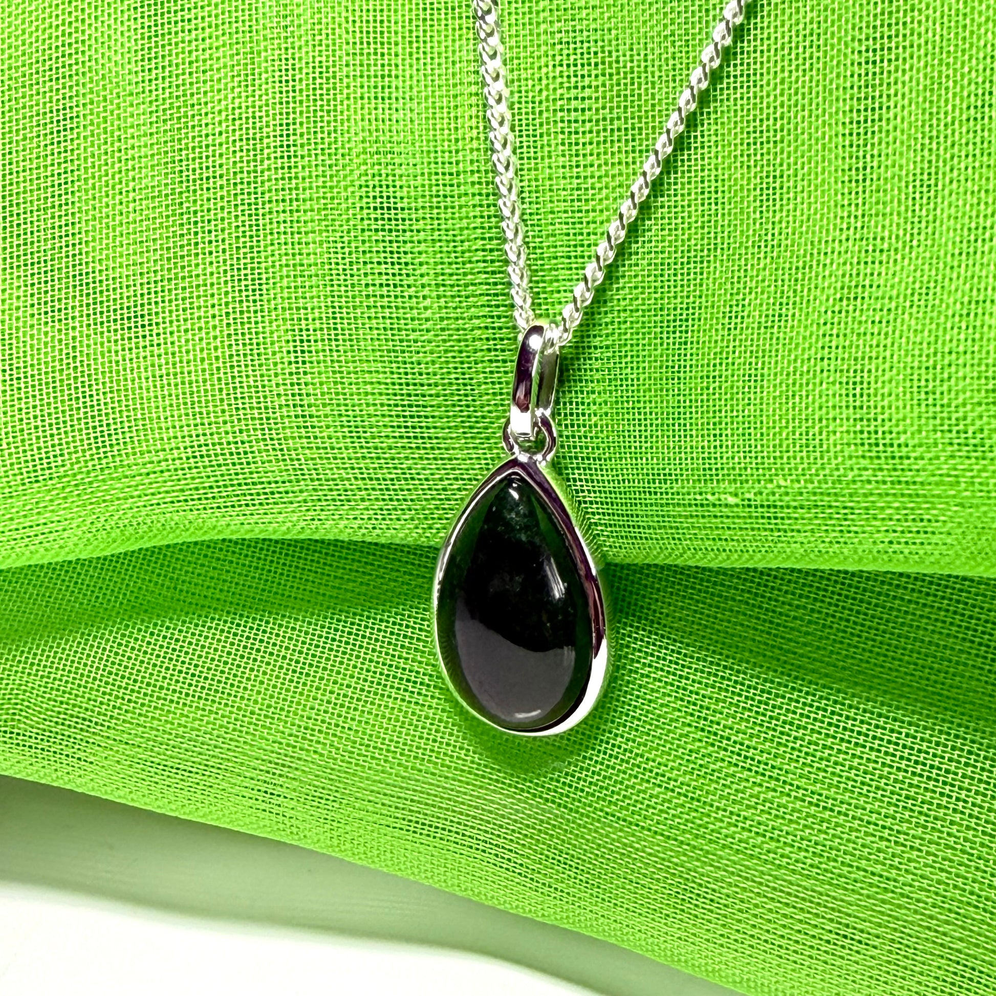 A real dark green jade necklace in a tear drop or pear shape smooth rub over setting