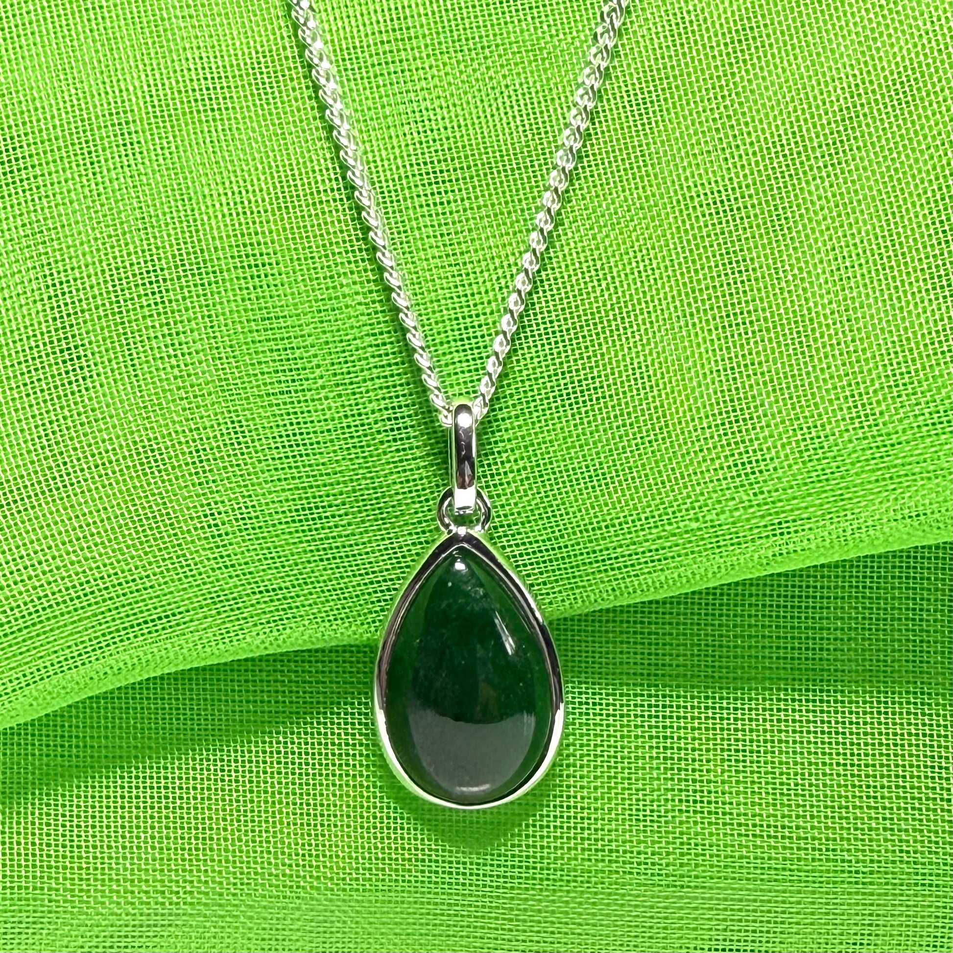 A real dark green jade necklace in a tear drop or pear shape smooth rub over setting with a chain