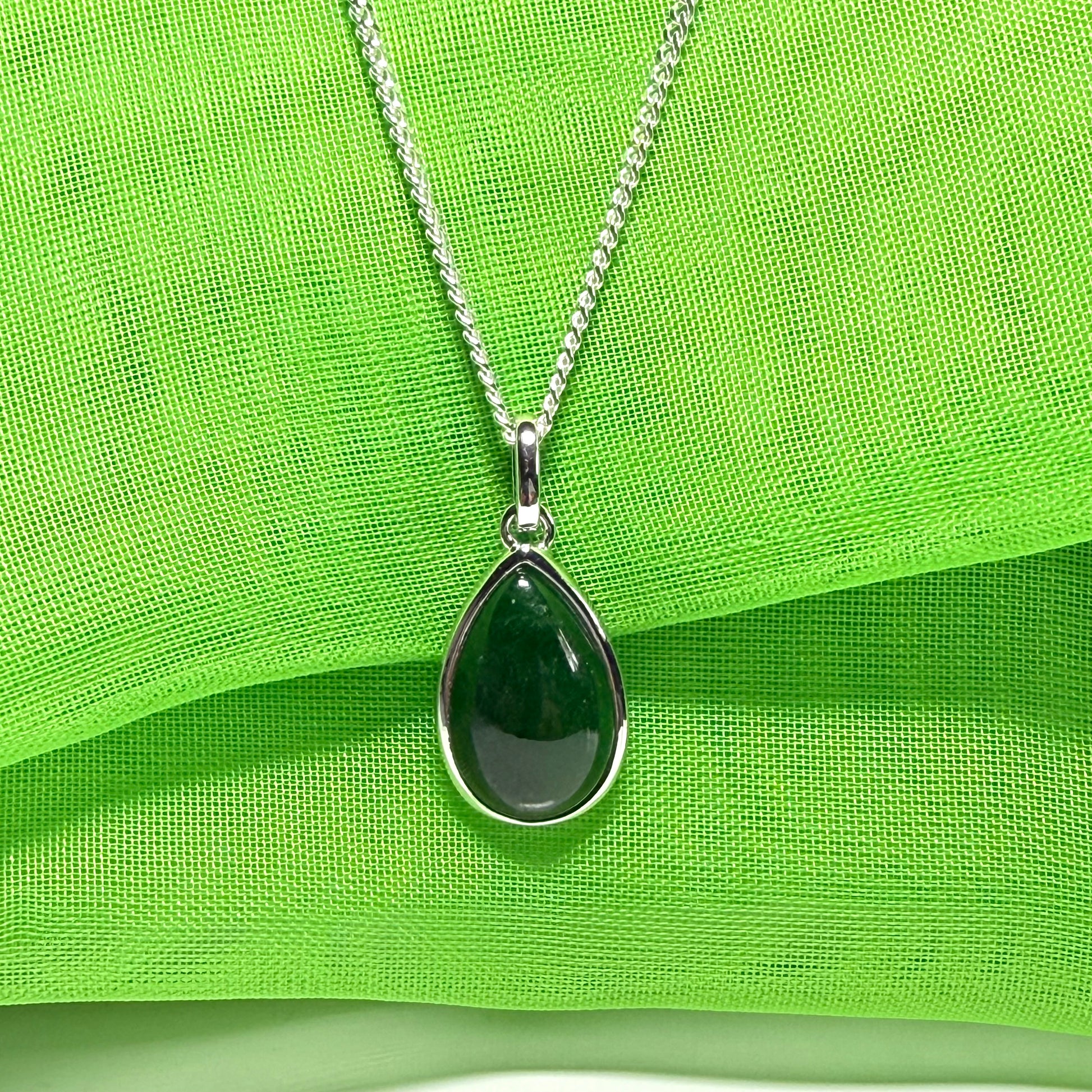 A real dark green jade necklace in a tear drop or pear shape smooth rub over setting with a chain