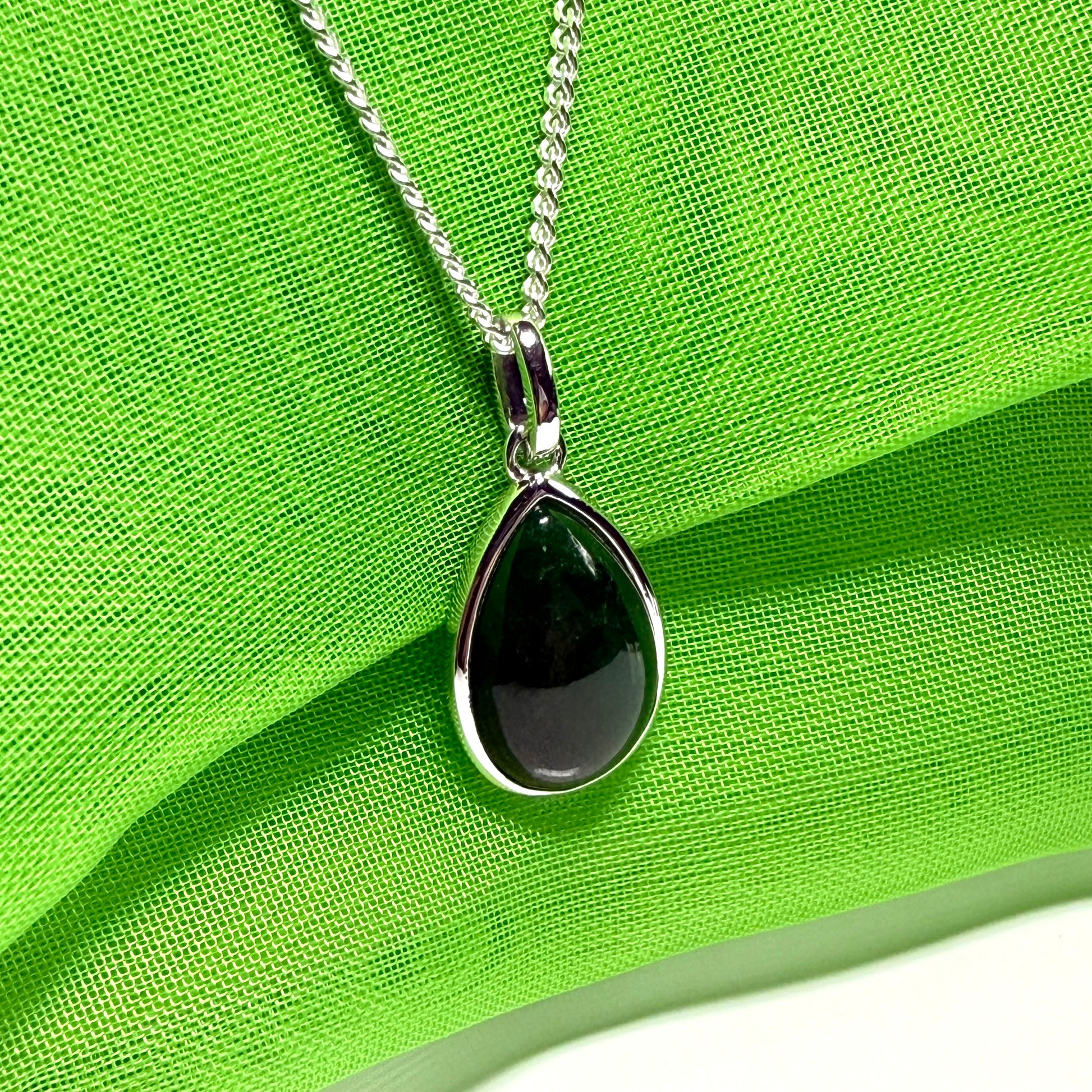 A real dark green jade necklace in a tear drop or pear shape smooth rub over setting