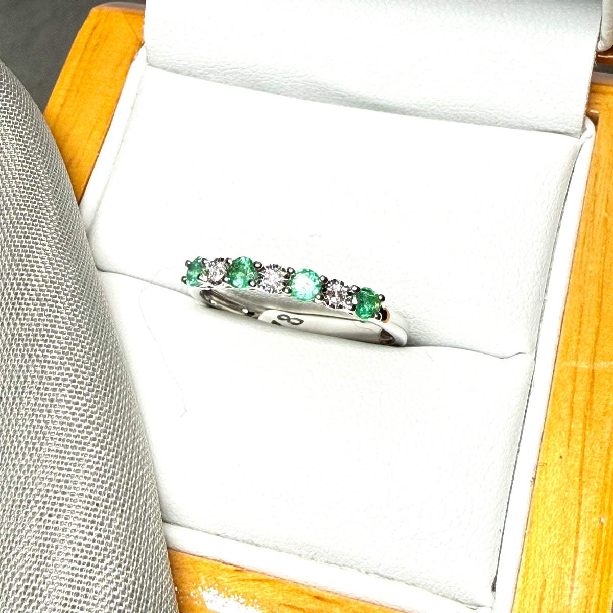 A real emerald and diamond white gold eternity ring claw setting
