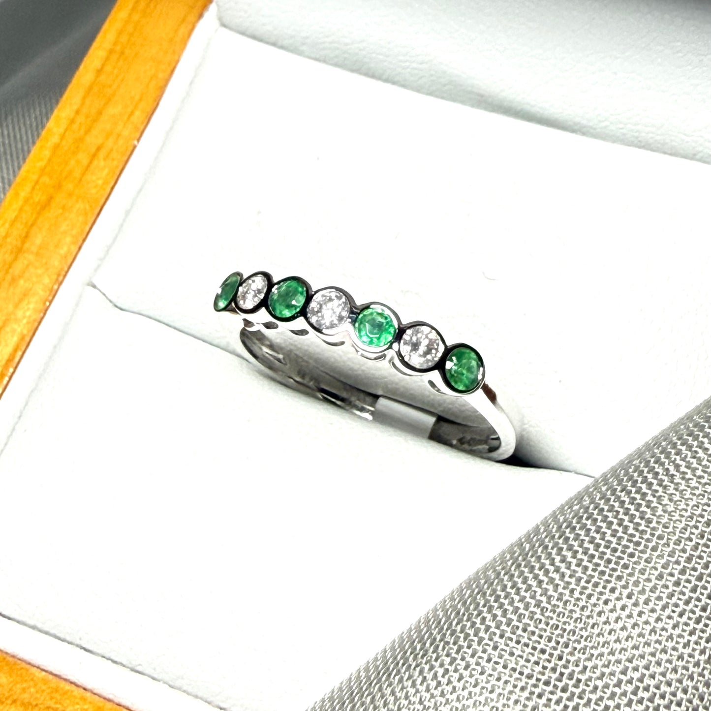 A real emerald and diamond white gold eternity ring smooth setting