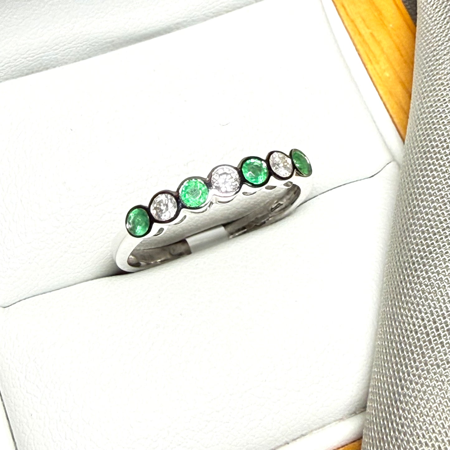 A real emerald and diamond white gold eternity ring smooth setting