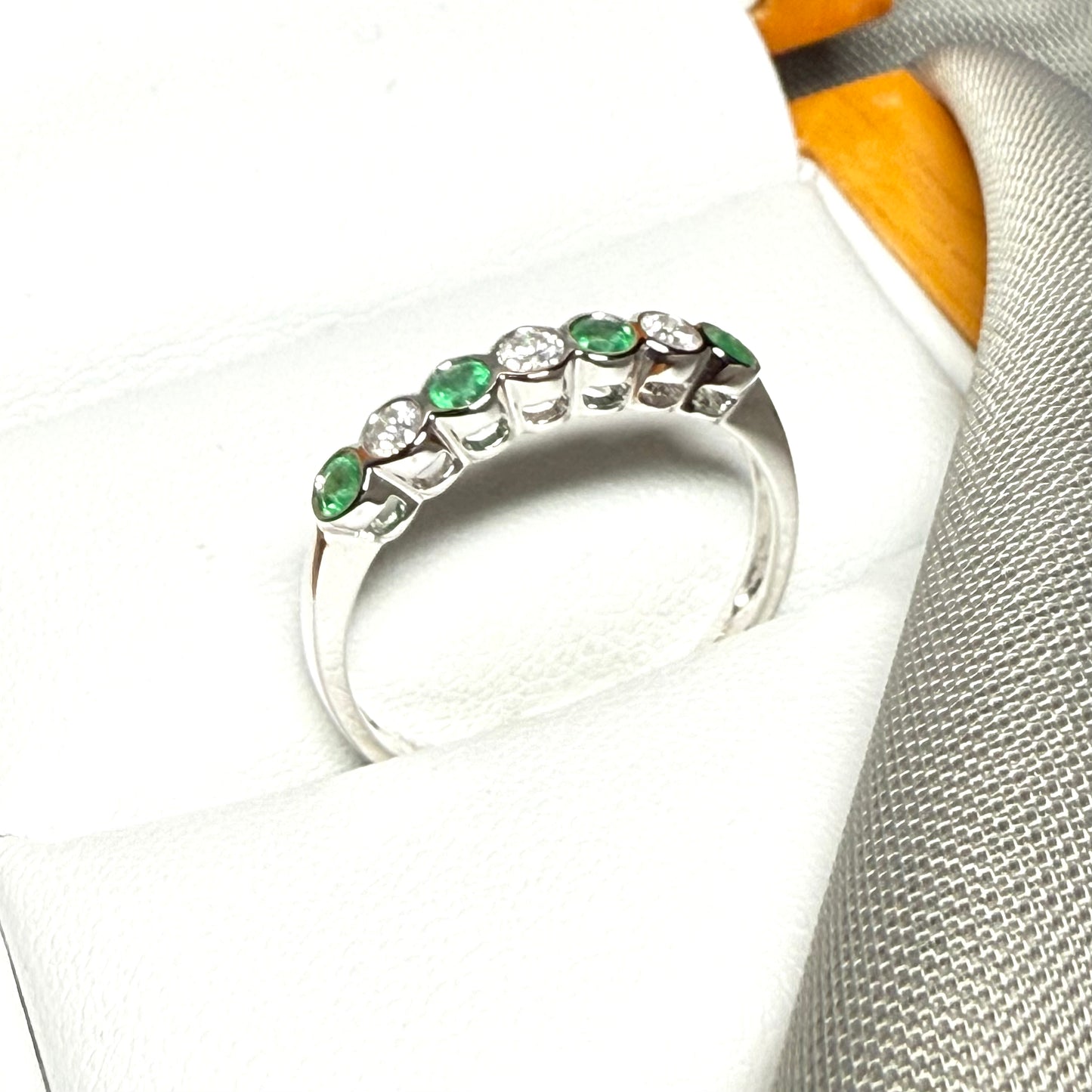 A real emerald and diamond white gold eternity ring with smooth setting