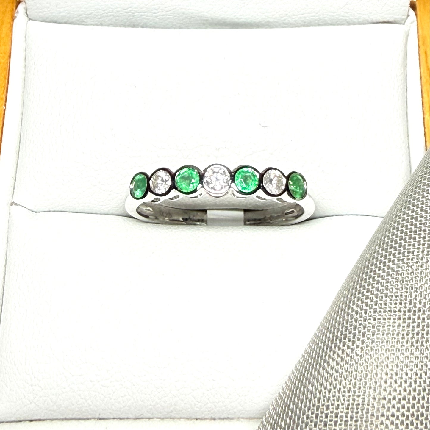 A real emerald and diamond white gold eternity ring smooth setting