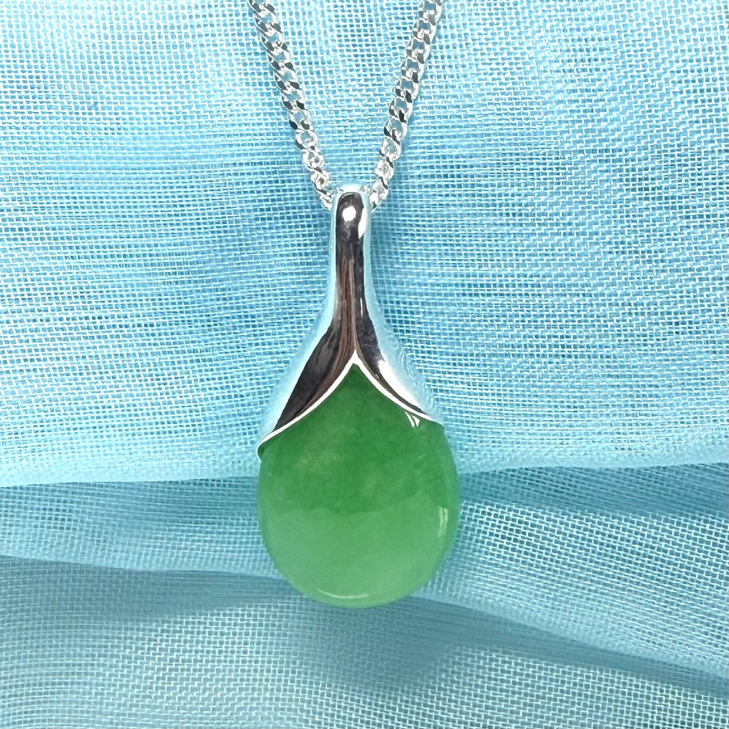 A real green jade necklace in a tear drop or pear shaped with a chain