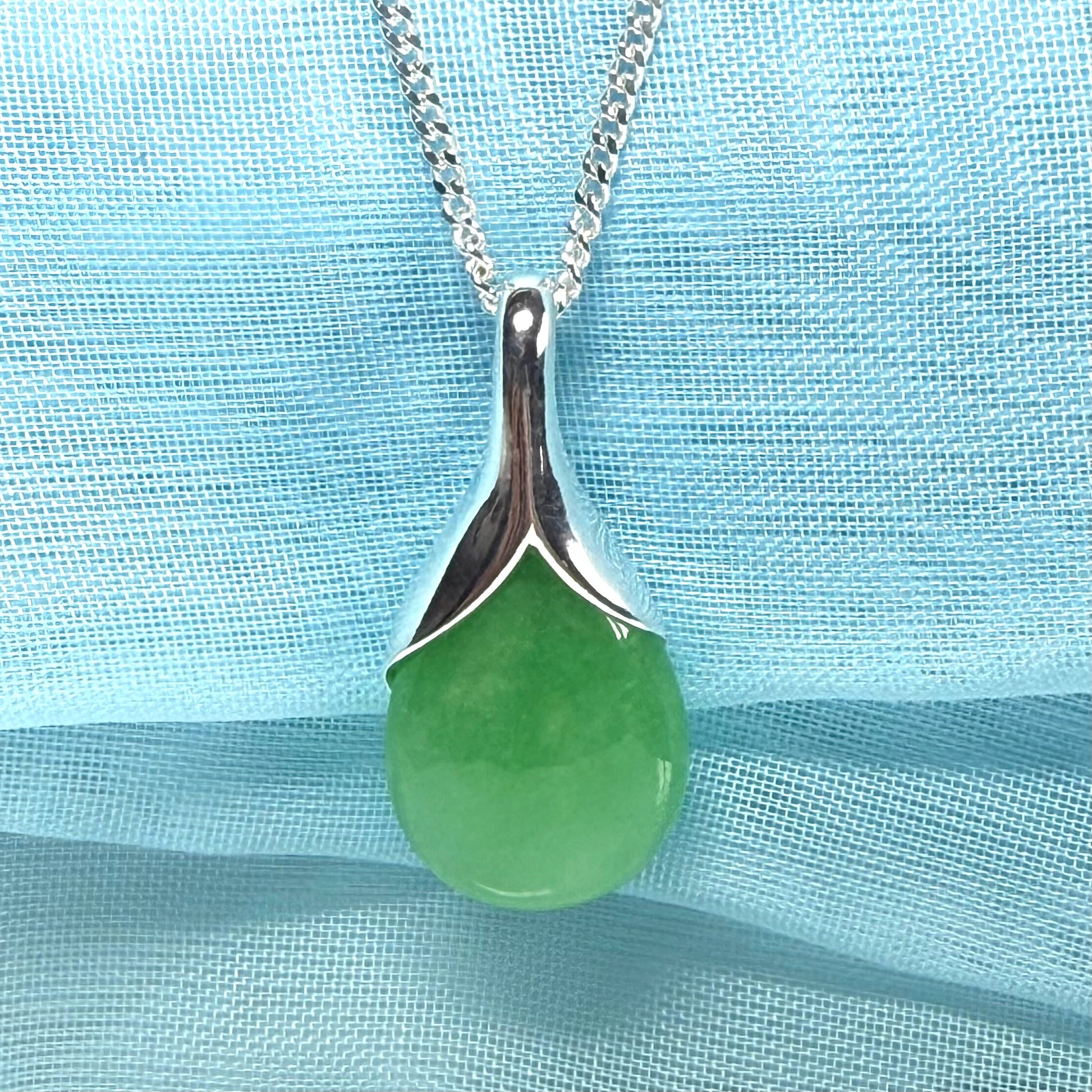 A real green jade necklace in a tear drop or pear shaped with a chain
