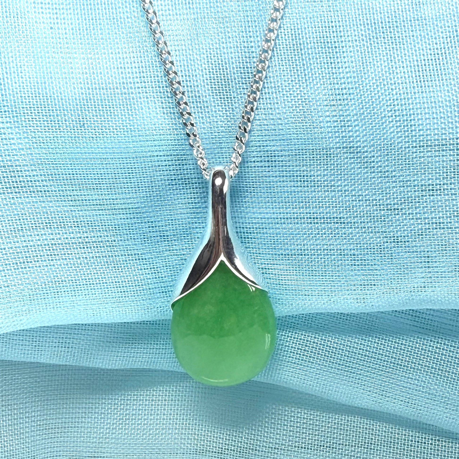 A real green jade necklace in a tear drop or pear shaped with a chain