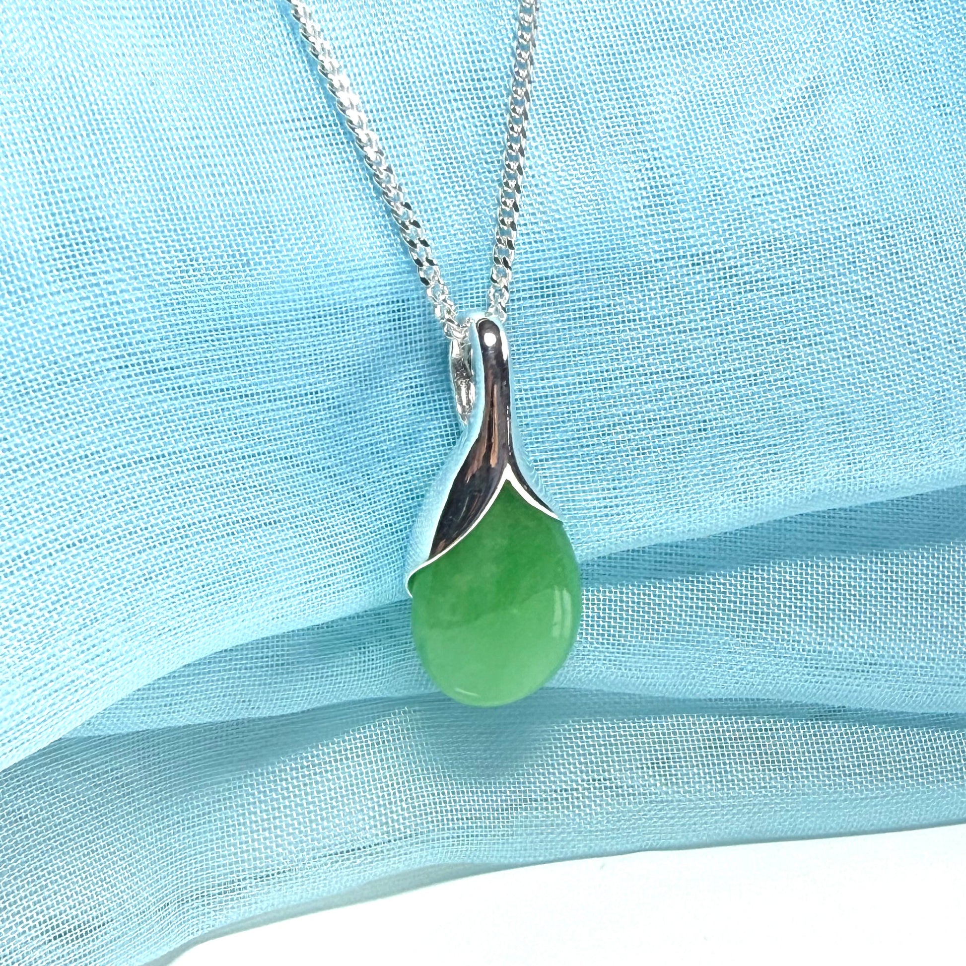 A real green jade necklace in a tear drop or pear shaped with a chain