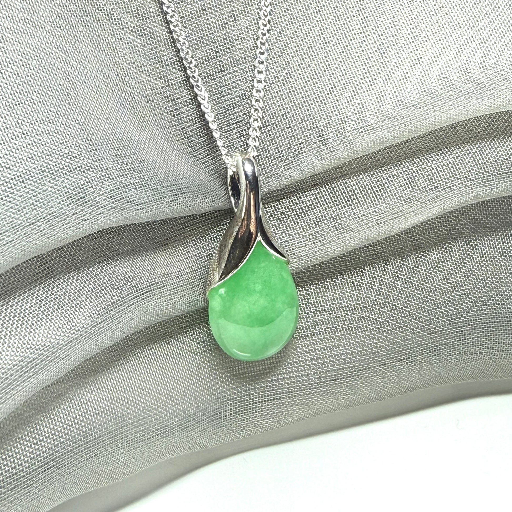 A real green jade necklace in a teardrop or a pear shape including a solid with a chain included