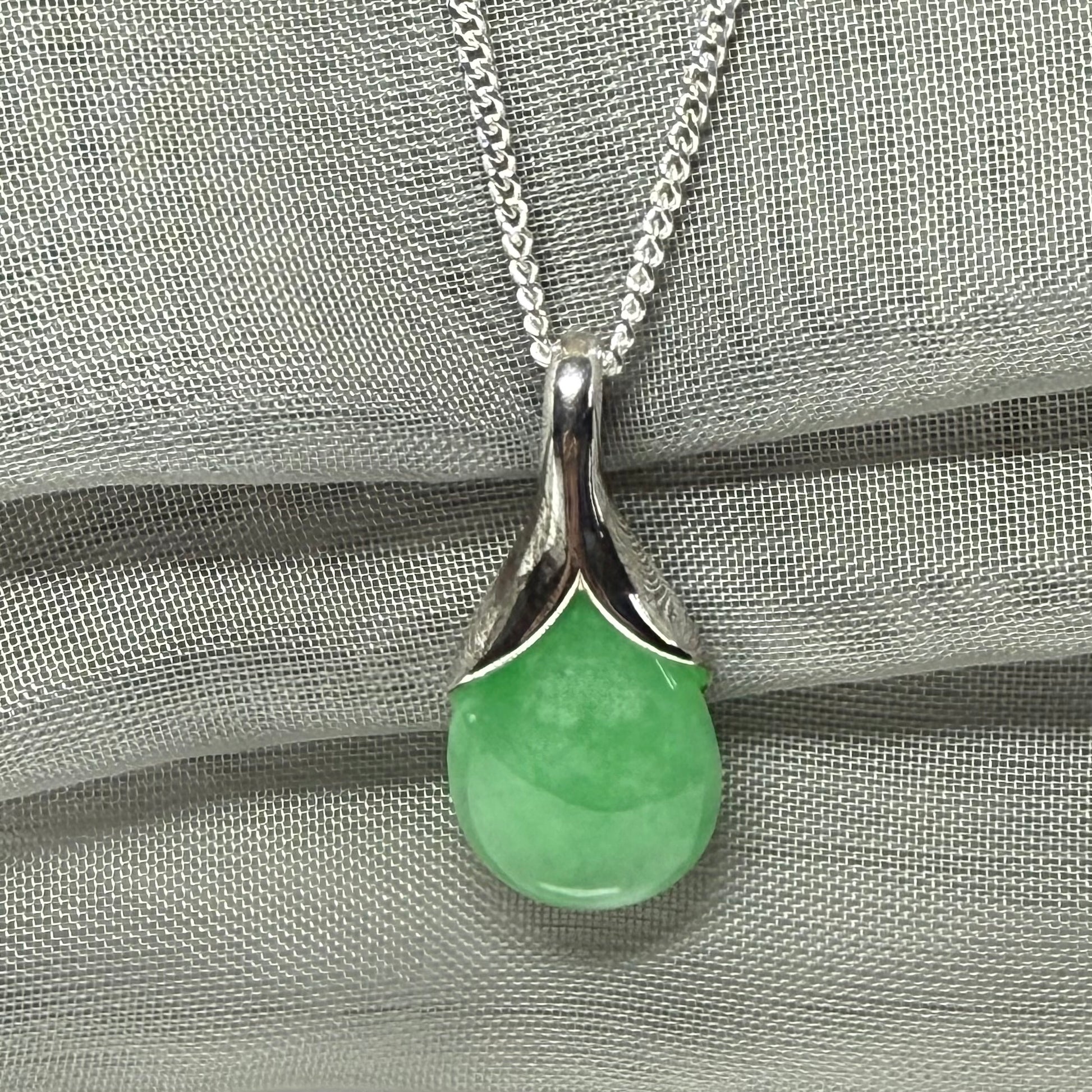 A real green jade necklace in a teardrop or a pear shape including a solid with a chain included