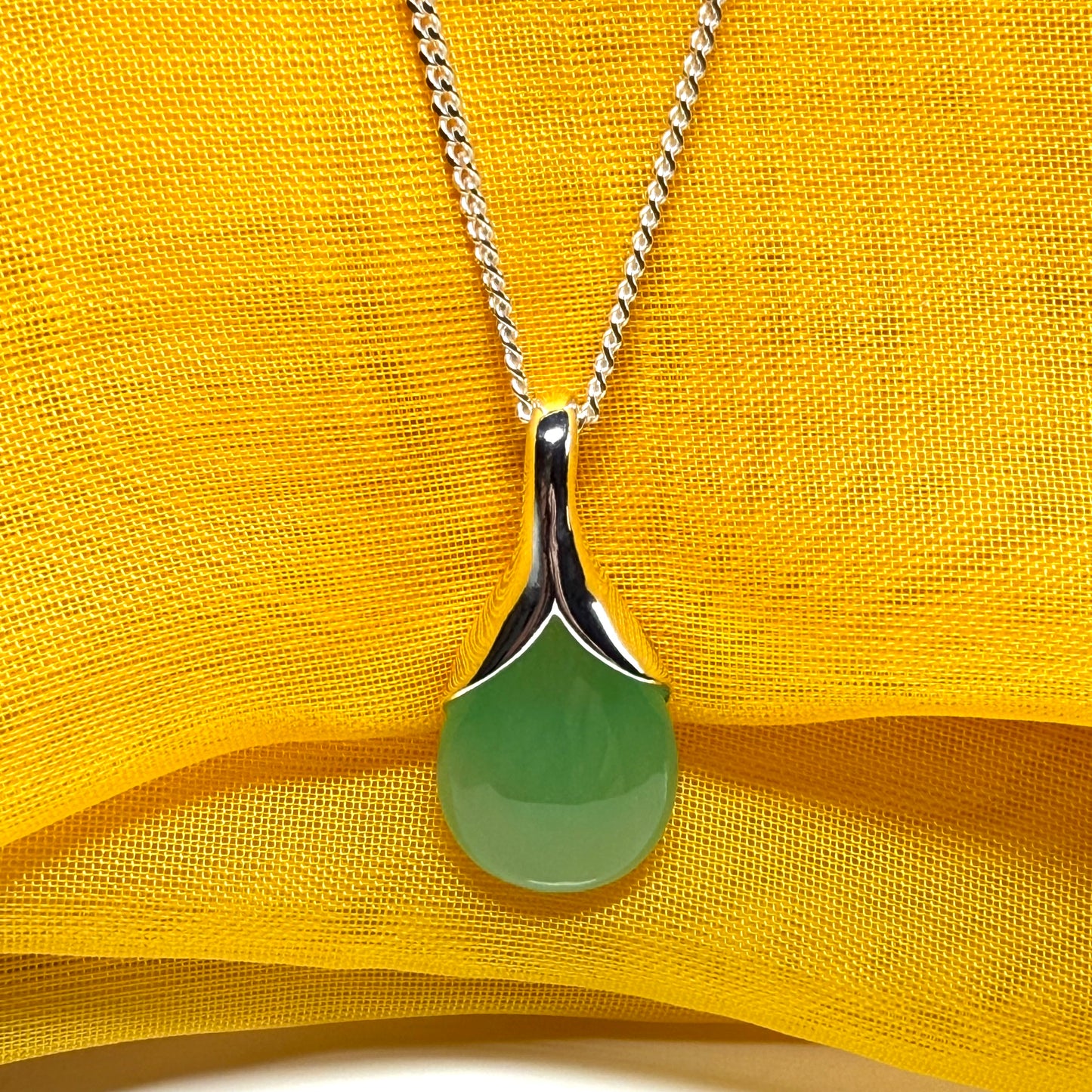 A real green jade necklace in a teardrop or pear shape with chain
