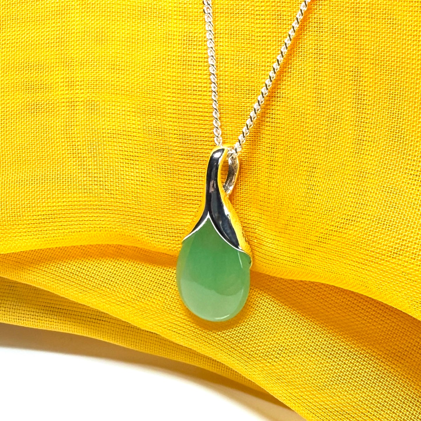 A real green jade necklace in a teardrop or pear shape with chain