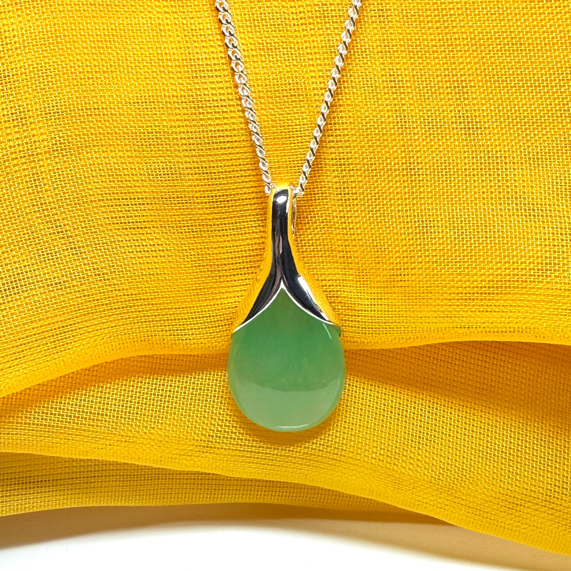 A real green jade necklace in a teardrop or pear shaped including a chain and a gift box included