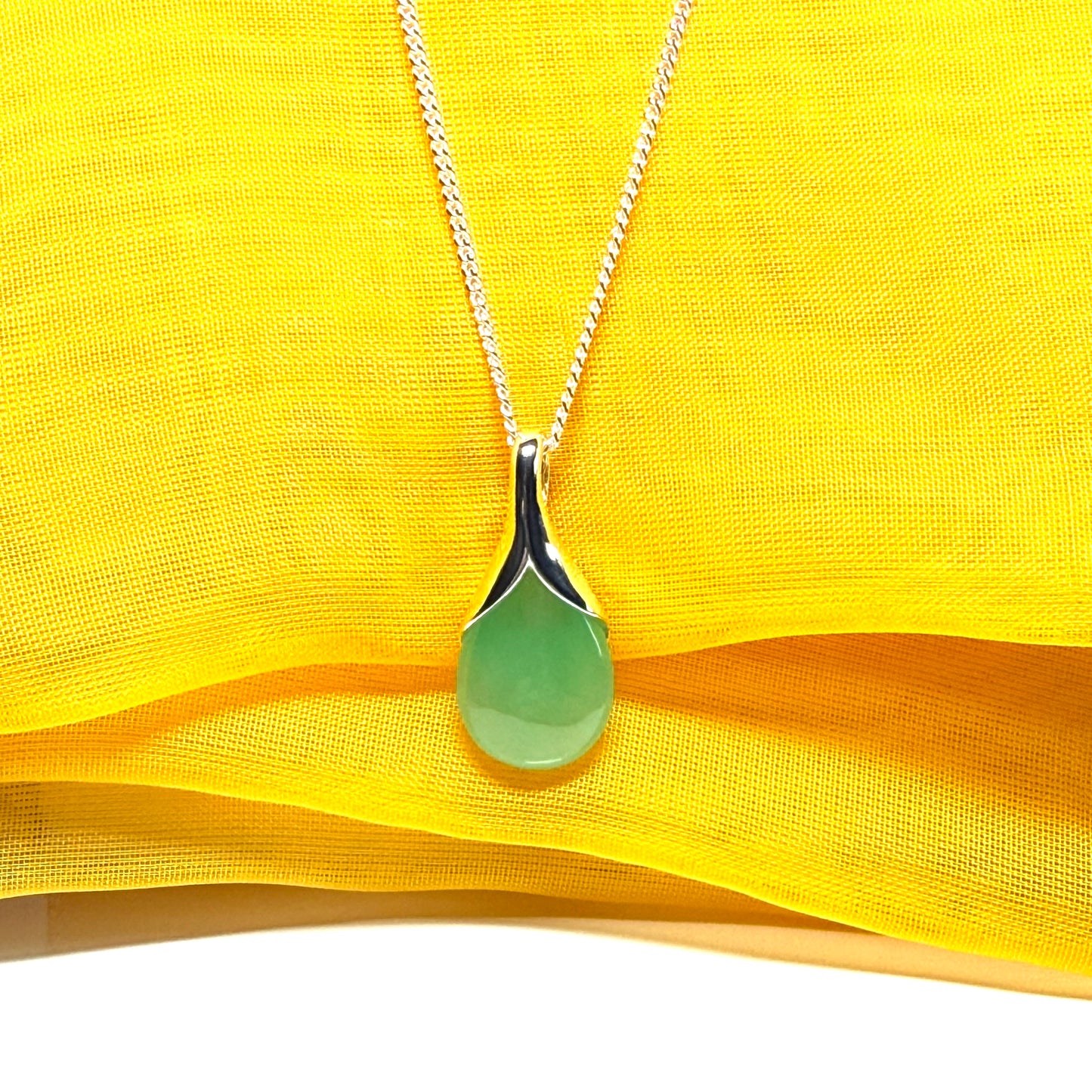 A real green jade necklace in a teardrop or pear shape with chain