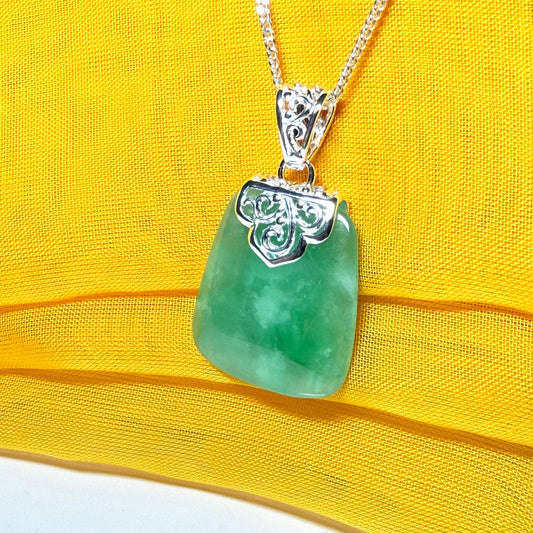 A real green jade necklace large shaped with a patterned top pendant with chain
