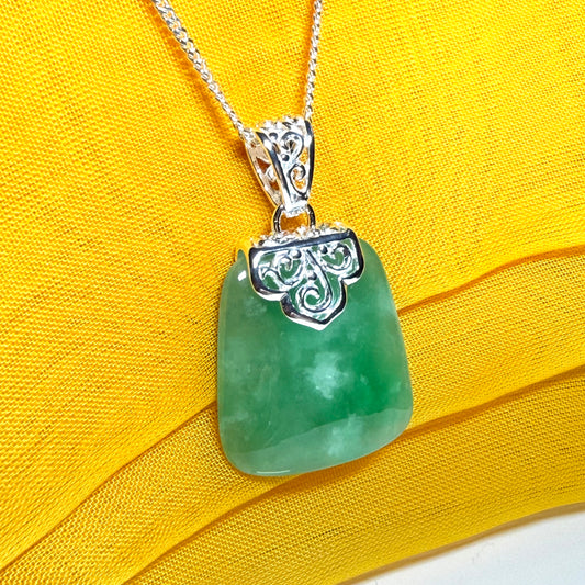 A real green jade necklace large shaped with a patterned top pendant with chain